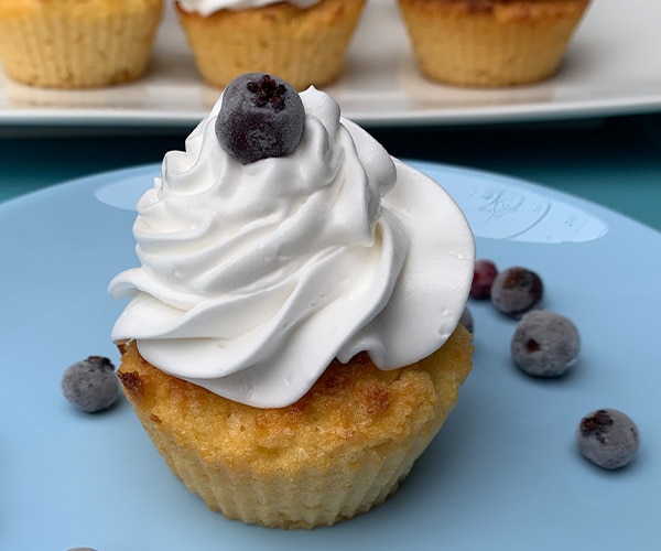 Brioșă fără gluten cu lămâie, servită cu frișcă și afine.